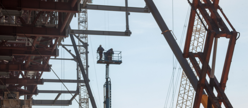 Construction workers performing overhead work from an elevated aerial platform